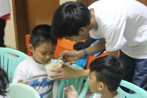 Mr. Rosario feeding one child in the Salapan Puericultural Center. 